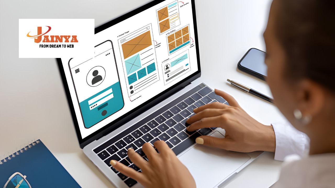 Team of web developers working on laptops and discussing website design in a modern office environment.